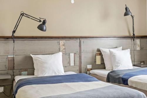 two beds in a hotel room with two lamps at Best Western Royal Holstebro in Holstebro