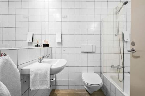 Best Western Royal Holstebro في هولستيبرو: حمام أبيض مع حوض ومرحاض