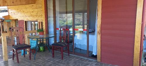 a patio with a table and chairs on a porch at Hospedaje el juncal in Puerto Ingeniero Ibáñez