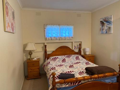 1 dormitorio con 1 cama y una ventana con cortinas azules en Mitcham Station Home Stay, en Mitcham