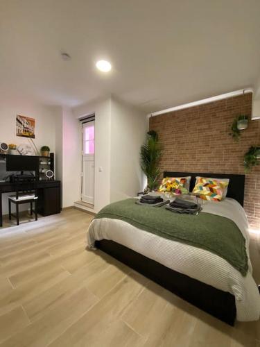 a bedroom with a large bed and a brick wall at Artistic Digital Getaway - Patio & GREAT Location! in Lisbon