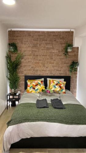 a bedroom with a large bed with a brick wall at Artistic Digital Getaway - Patio & GREAT Location! in Lisbon