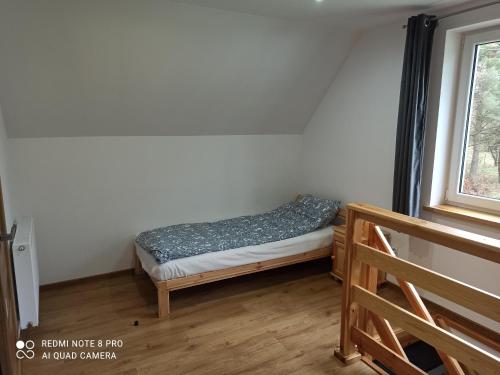 a small bed in a room with a window at Apartameny Wiktoria i Nikola w Karwiku in Pisz