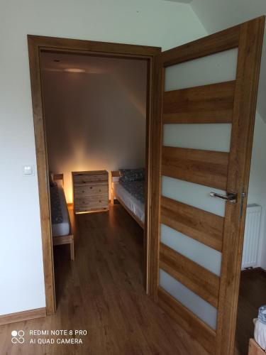 a door to a bedroom with a bed in a room at Apartameny Wiktoria i Nikola w Karwiku in Pisz