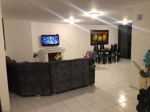 sala de estar con sofá y TV en Home Travel Popayan, en Popayán