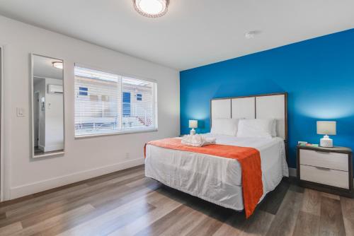 1 dormitorio con 1 cama grande y pared azul en The Mariner Suites #24, en Hollywood