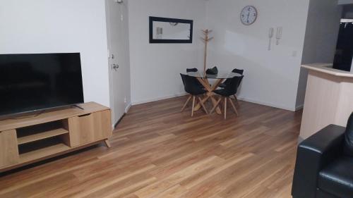 a living room with a television and a wooden floor at Blue Waters Apartments in Gold Coast