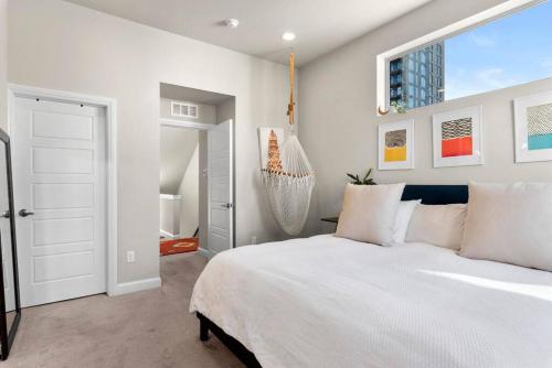 Un dormitorio con una gran cama blanca y una ventana en Hip Townhome w/ Rooftop VIEWS - Walk to Everything, en Denver