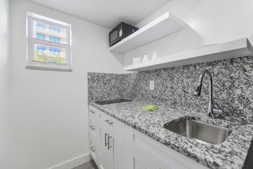 a white kitchen with a sink and a window at Peaceful Studio by the Beach with Parking - M25 in Hollywood