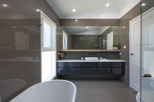 a bathroom with a sink and a large mirror at New luxury home, walking distance to CBD in Wagga Wagga