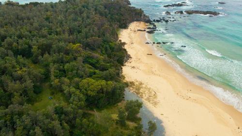 an aerial view of a beach next to the ocean at Mystery Bay Cottages in Mystery Bay