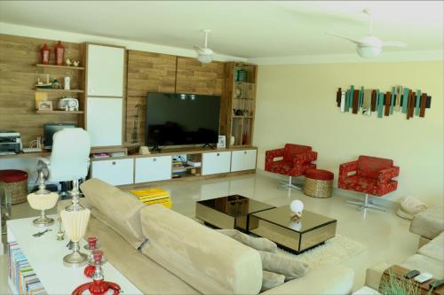 ein Wohnzimmer mit Sofa und Fernseher in der Unterkunft Casa Maravilhosa na Ferradura in Búzios