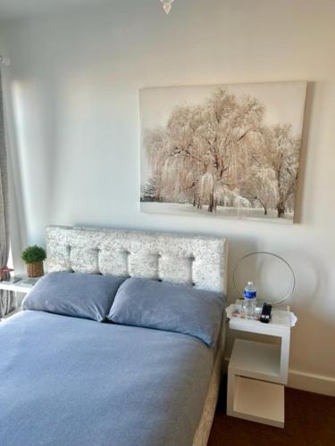 a bedroom with a blue bed and a picture on the wall at The Quay in Newhaven