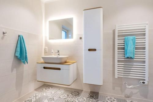 uma casa de banho branca com um lavatório e um espelho em Ferienhof Marquardt Bungalow 2 em Fehmarn