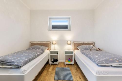 duas camas sentadas uma ao lado da outra num quarto em Ferienhof Marquardt Bungalow 2 em Fehmarn