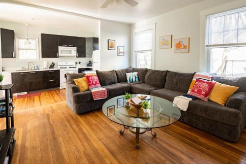 a living room with a couch and a glass table at Globetrotters Suite in Historic Richmond with Patio in Richmond