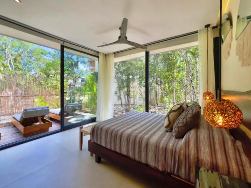 图卢姆Jungle-chic luxurious Tulum home的一间卧室设有一张床和一个大型玻璃窗