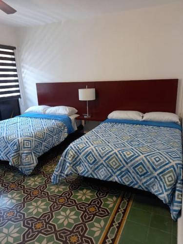 um quarto de hotel com duas camas e um tapete em Casa En El Centro Histórico De Morelia em Morelia