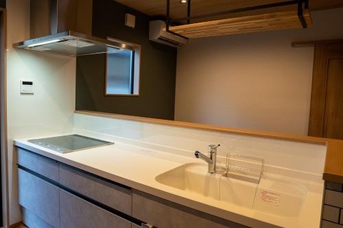 a bathroom with a sink and a mirror at Second Home 瀬戸風月 in Takamatsu