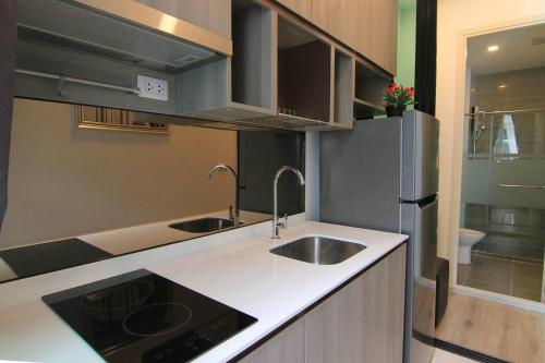 a small kitchen with a sink and a refrigerator at New Condo, Hi-Speed Wi-Fi, Gym Pool, near Lam Sali MRT in Bangkok