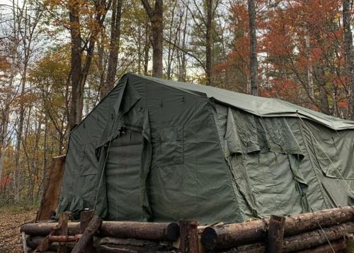 una tenda verde in mezzo a una foresta di Pre Hub 十勝 