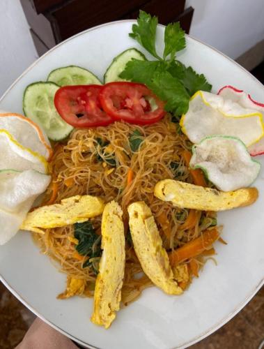 a plate of food with spaghetti and vegetables on it at Villa Copenhagen Bukittinggi in Bukittinggi