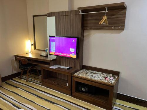 a room with a desk with a computer and a television at Nova Hotel Miri in Miri