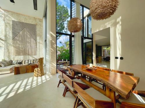 a dining room with a wooden table and chairs at Jungle-chic luxurious Tulum home in Tulum