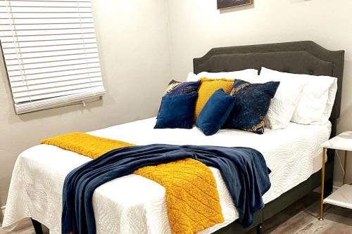 a bed with blue and yellow blankets and pillows at NEW! close to Downtown, Malls & Premium Outlets, with Balcony in Weslaco