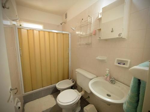 y baño con aseo, lavabo y ducha. en Kau hostel & experiencias en Perito Moreno