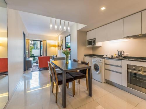 曼谷的住宿－美蒂雅素坤逸18巷酒店 - 察殿集团精选系列，厨房以及带桌椅的用餐室。