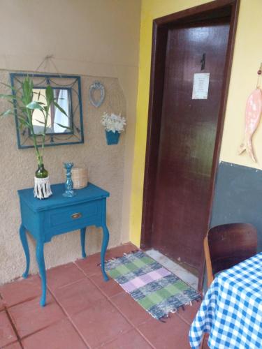 a room with a blue table next to a door at Pousada Sol das Amendoeiras in Saquarema