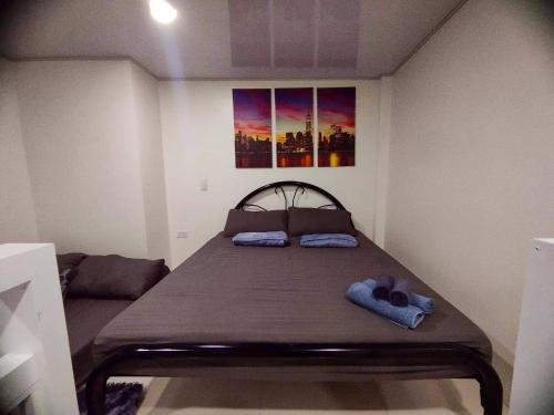 een bed in een kamer met twee handschoenen erop bij Minimalist Loft 107 in Baguio