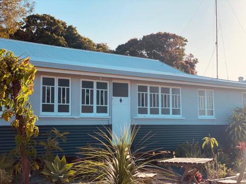 ein blaues Haus mit blauem Dach in der Unterkunft Original Pier Beach Retreat - Child Pet Friendly in Urangan