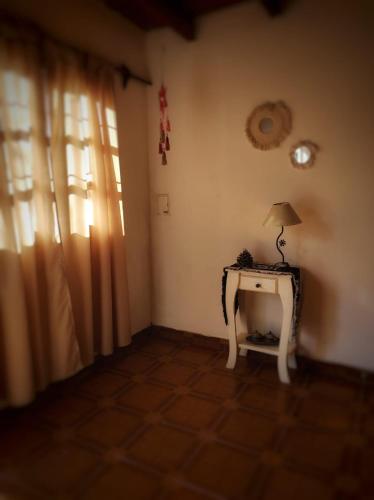 una habitación con una mesa con una lámpara. en Departamento Cómodo e impecable en Tunuyán a metros de restaurantes , acceso a Manzano historico - capacidad 4 personas en Tunuyán