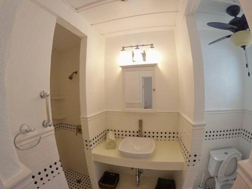 ein weißes Bad mit einem Waschbecken und einem WC in der Unterkunft Cozy Beachfront Apartment with Bay views in East End