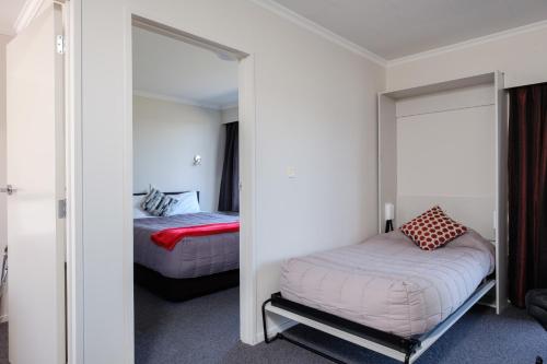 a bedroom with two beds and a mirror at Esplanade Motels in Gore