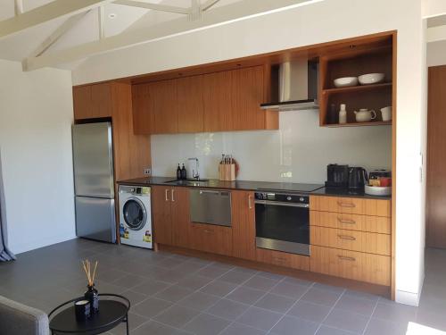 a kitchen with wooden cabinets and a stainless steel appliance at Cable Bay Guesthouse in Blackpool