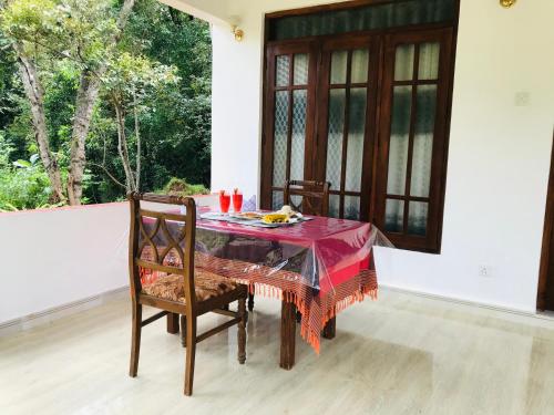 a dining room table with a red table cloth on it at Holly Flowers Villa in Sigiriya