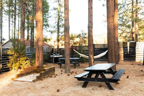 a picnic table and a hammock in the woods at NP Boutique Lodge in Big Bear Lake