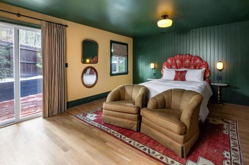 a bedroom with a bed and two chairs at NP Boutique Lodge in Big Bear Lake