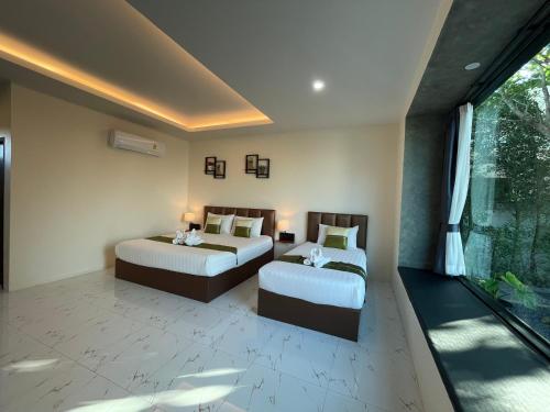 a bedroom with two beds and a large window at Dark Sugar Resort in Ban Bo Thong