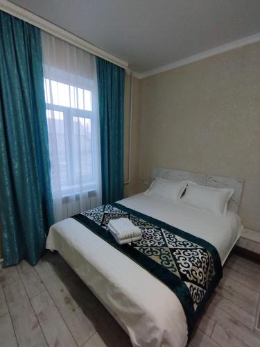 a bedroom with a large bed with a window at Pravda in Bishkek