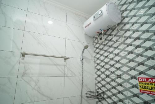un cabezal de ducha en la pared del baño en RedDoorz near Stasiun Senen, en Yakarta