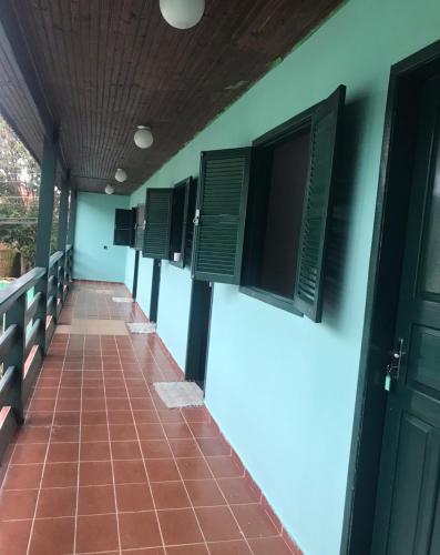 a row of shutters on a building with a tile floor at Pousada Estrela Dalva in Paraty