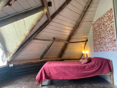 Una cama con una manta roja en un ático en Descanso, aventura y ecoturismo en las sierras in 