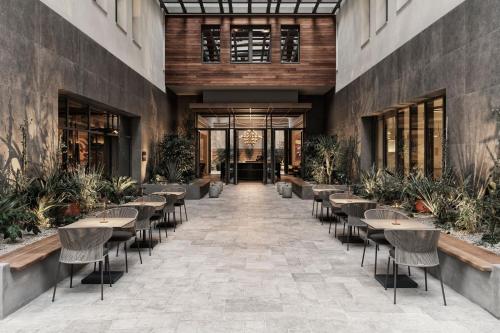 a hallway with tables and chairs in a building at MonAsty, Thessaloniki, Autograph Collection in Thessaloniki