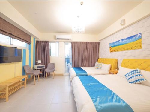 吉安的住宿－藍海筑夢城民宿，酒店客房配有两张床和一张书桌