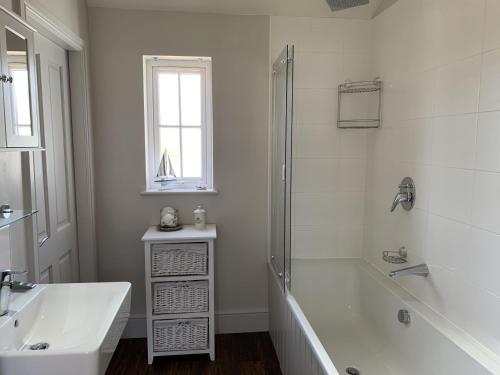 a white bathroom with a tub and a sink at Blue Bay at The Bay Filey, sleeps 4-6, 2 dogs welcome for free too in Filey