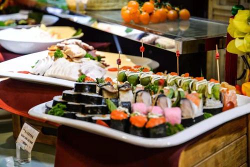 a display of sushi and other foods on a table at Guangzhou Phoenix City Hotel-Free Shuttle for Canton Fair 15th Oct to 5th Nov in Zengcheng